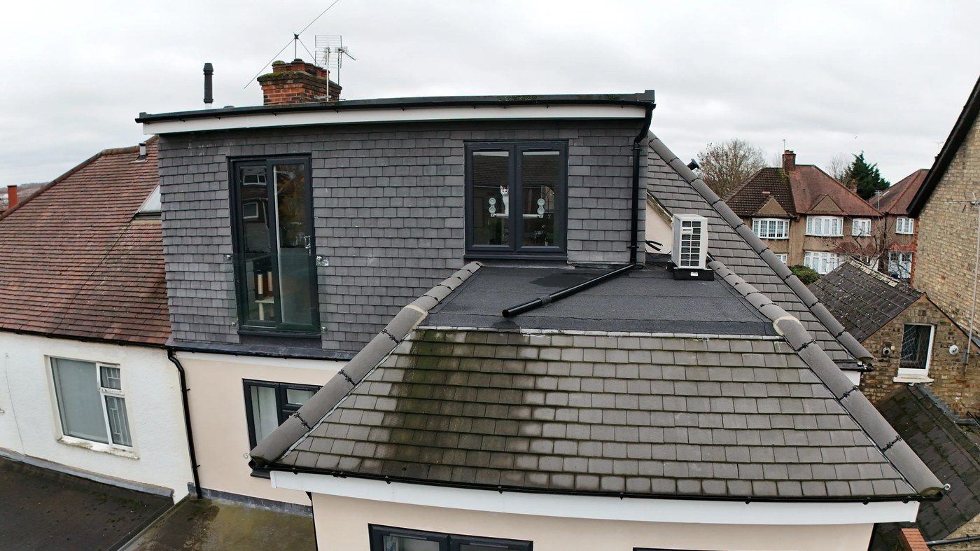 Rear oblique elevation showing flat roof deck, ASHP unit, and hip junctions