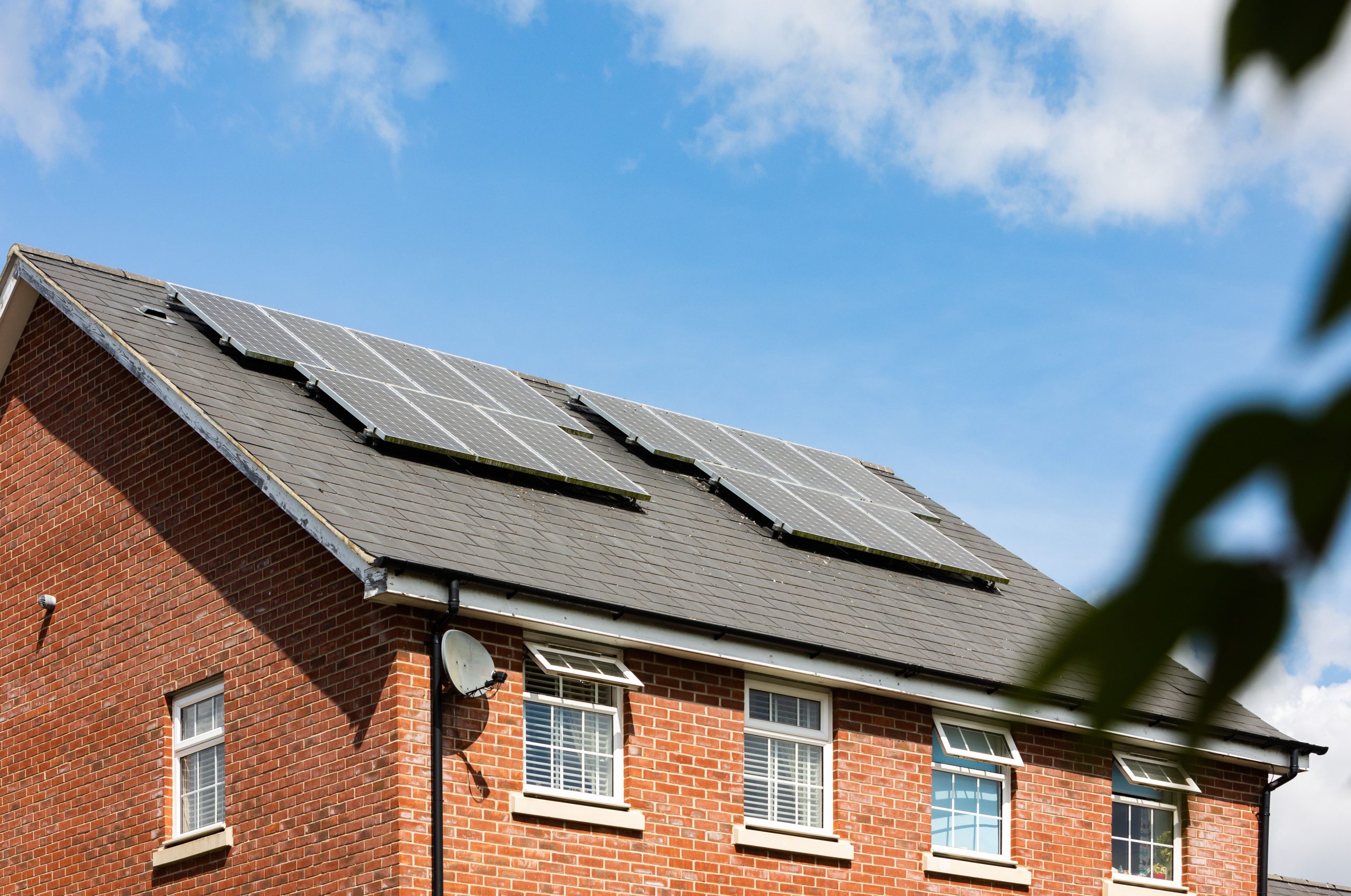 Solar panels installed on the roof of a red brick house